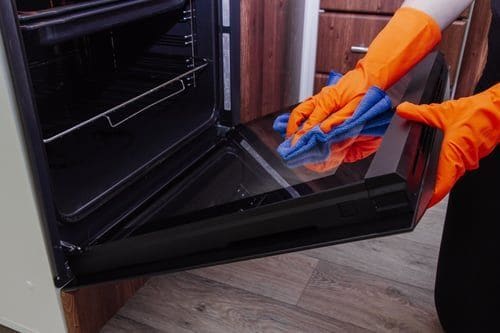 Professional cleaner deep cleaning an oven interior during a Las Vegas deep cleaning service
