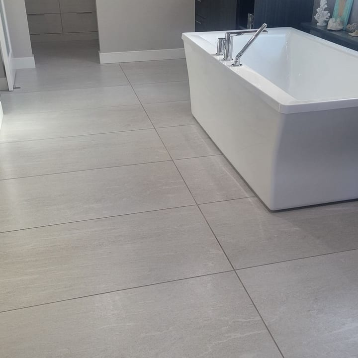 Bathroom with a freestanding tub and large-format tile floor after cleaning