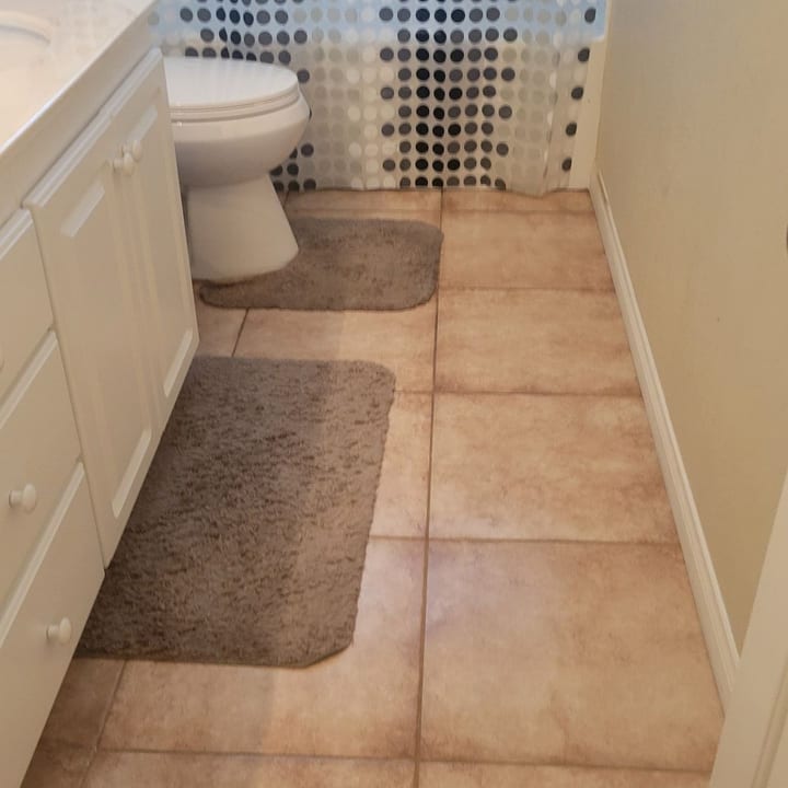 Bathroom tile floor and bath mats after a deep clean